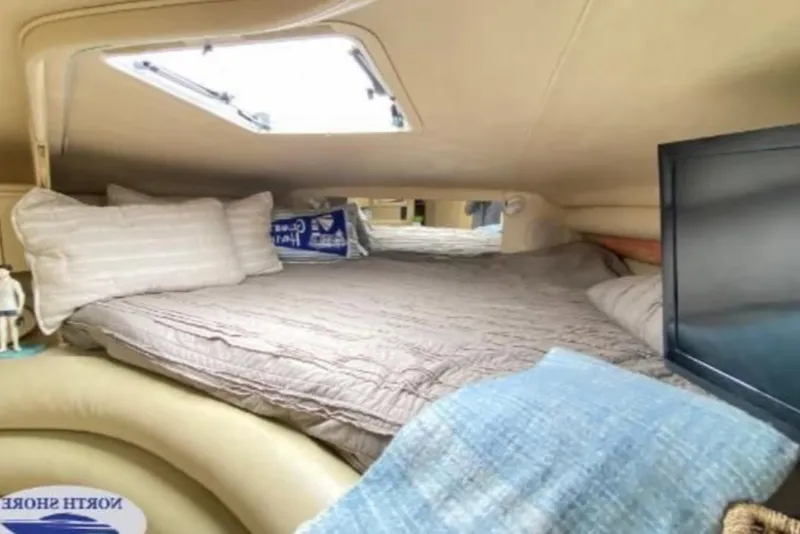 Slide: The Image of Cozy cabin interior of 1998 Sea Ray 310 Sundancer with bed and skylight. - 11