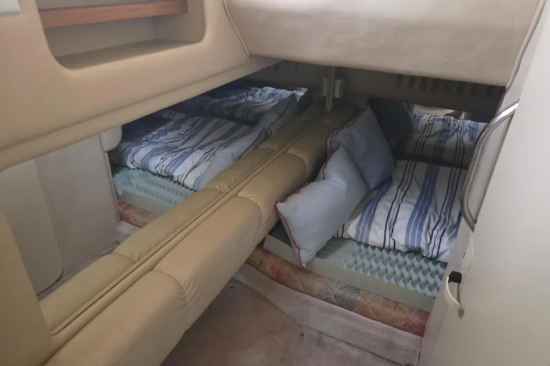 Slide: The Image of Interior cabin of 1998 Sea Ray 310 Sundancer with striped bedding and cushions. - 13