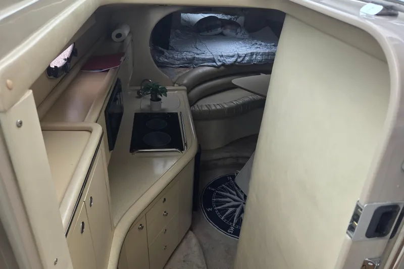Slide: The Image of 1998 Sea Ray 310 Sundancer cabin interior with kitchenette and sleeping area. - 14
