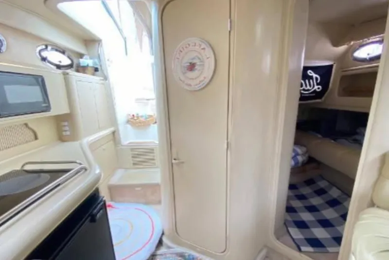 Slide: The Image of 1998 Sea Ray 310 Sundancer interior with kitchenette and cozy cabin area. - 15