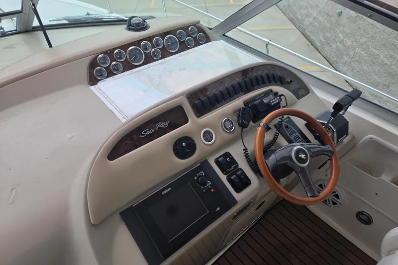Slide: The Image of 1998 Sea Ray 310 Sundancer helm with gauges, steering wheel, and navigation equipment. - 4