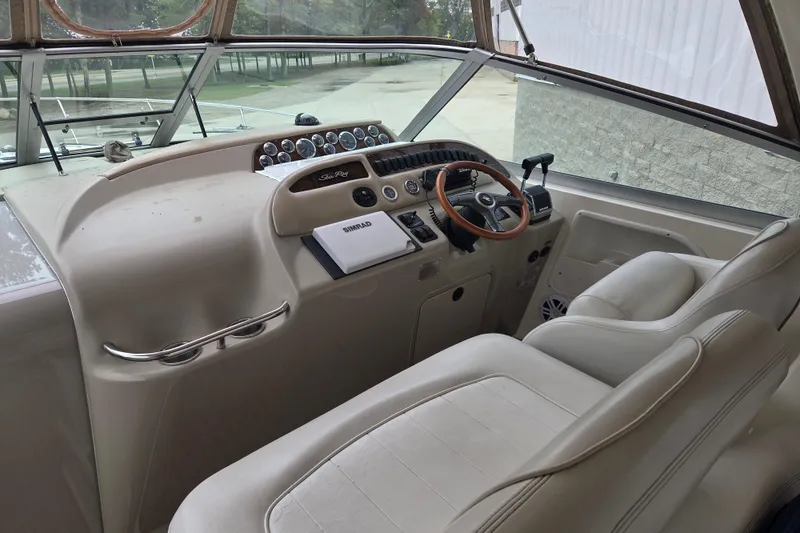 Slide: The Image of 1998 Sea Ray 310 Sundancer helm with steering wheel and control panel. - 5