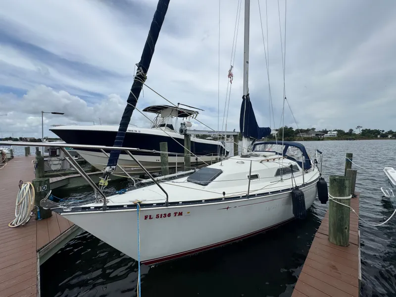 The Image of 1986 C&C 29 sailboat docked at marina, overcast sky, calm water. - 0