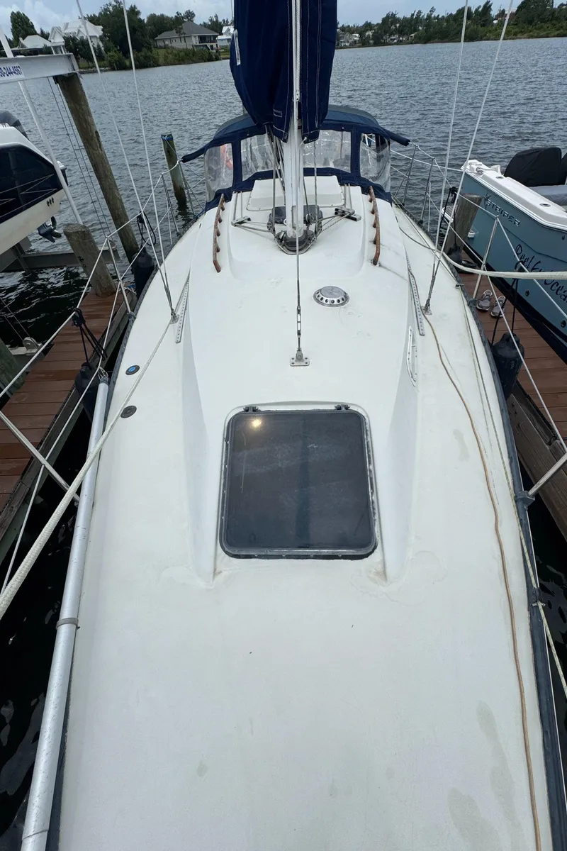 Slide: The Image of 1986 C&C 29 sailboat docked at a marina, view of the deck and hatch. - 19