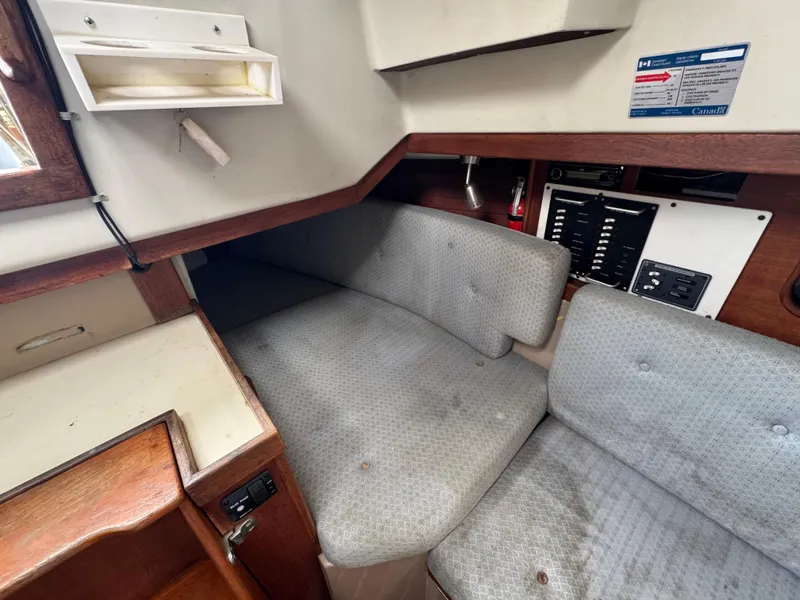 Slide: The Image of Interior of a 1986 C&C 29 sailboat, featuring a cozy seating area and control panel. - 27