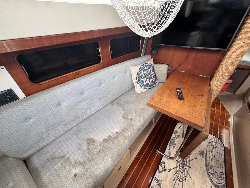 Slide: The Image of Interior of 1986 C&C 29 sailboat with sofa, wooden table, and nautical decor. - 28