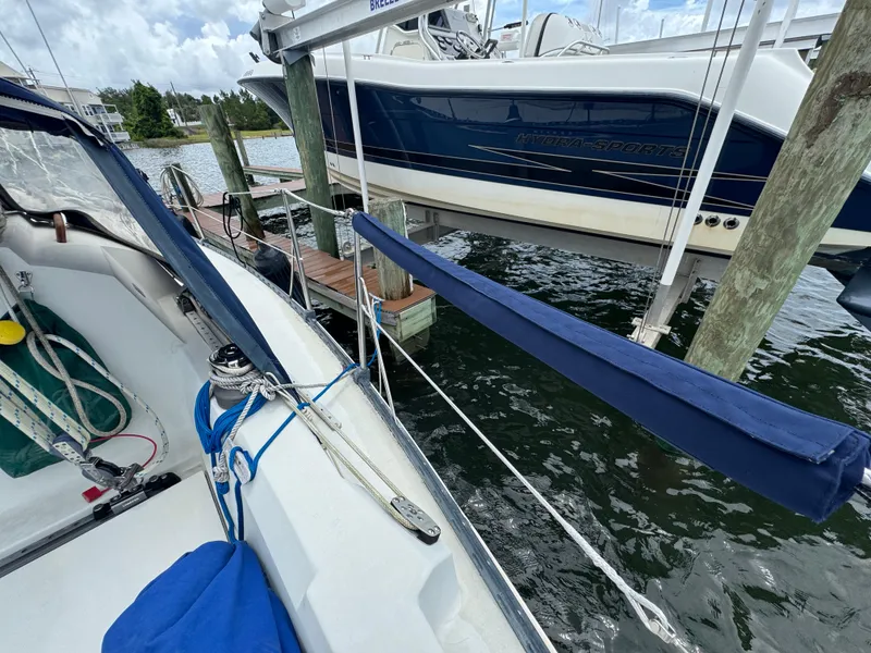 Slide: The Image of Sailboat docked beside a motorboat, featuring a C&C 29 model from 1986. - 6