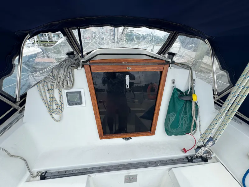 Slide: The Image of 1986 C&C 29 sailboat cockpit with ropes, navigation equipment, and wooden hatch. - 8