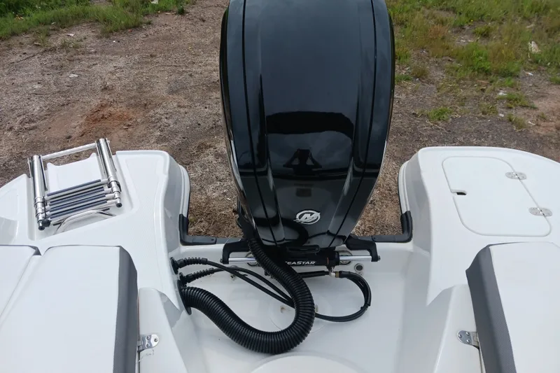 Slide: The Image of 2025 Tahoe 200 S boat engine and swim platform with ladder, on grassy terrain. - 10