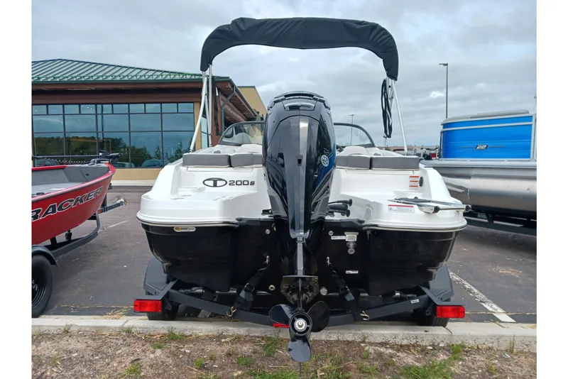 Slide: The Image of 2025 Tahoe 200 S boat with outboard motor, parked in a lot. - 3