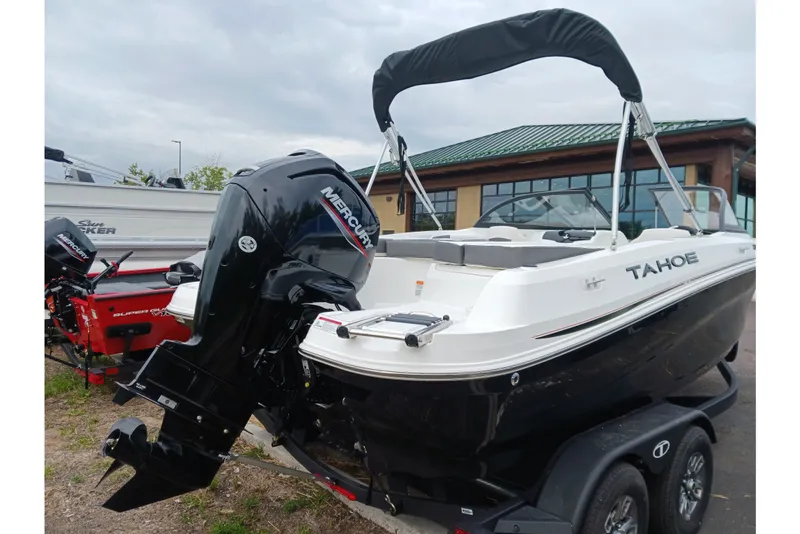 Slide: The Image of 2025 Tahoe 200 S boat with Mercury outboard motor, parked on a trailer. - 2