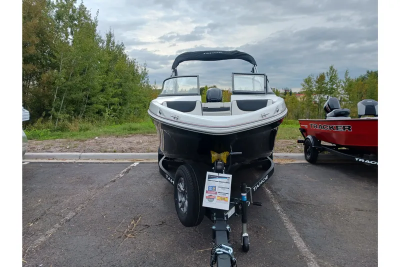 Slide: The Image of 2025 Tahoe 200 S boat on trailer in parking lot, surrounded by trees. - 1