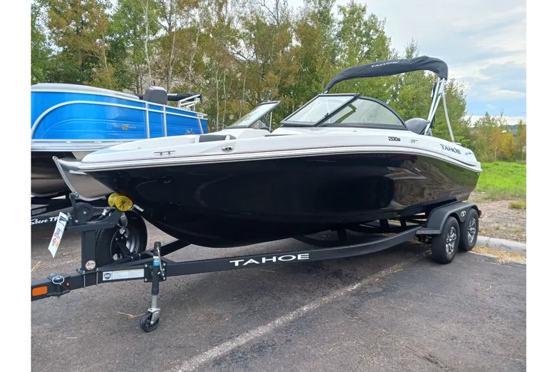 The Image of 2025 Tahoe 200 S boat on trailer, parked outdoors with trees in background. - 0