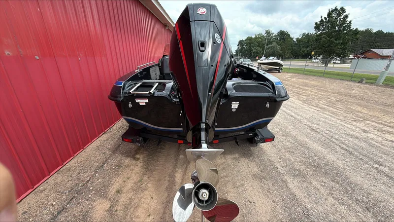 Slide: The Image of 2025 Nitro ZV19 boat with powerful outboard motor, parked beside a red building. - 5