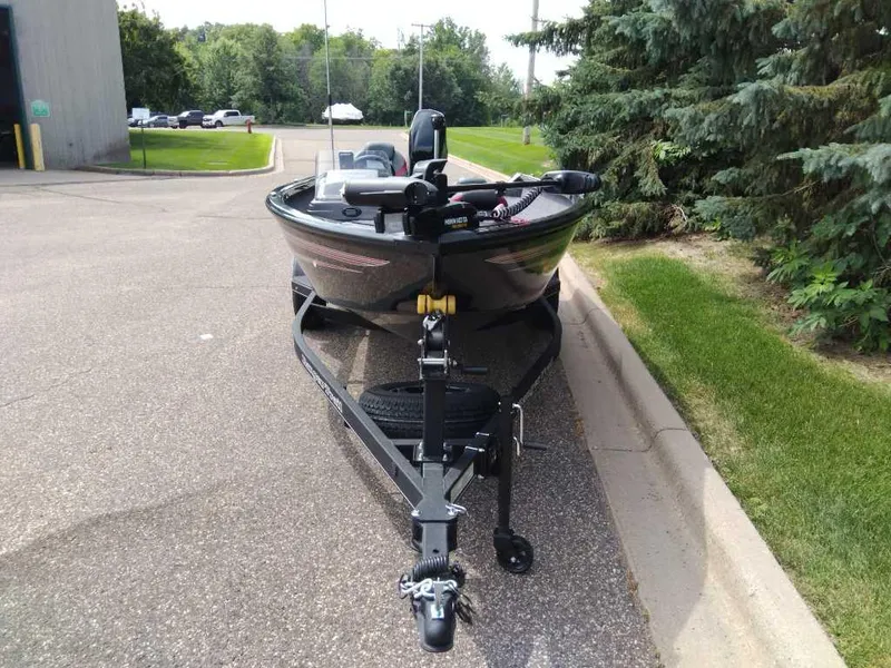 Slide: The Image of 2025 Ranger VS1665SC boat on trailer, parked on a paved road near greenery. - 3