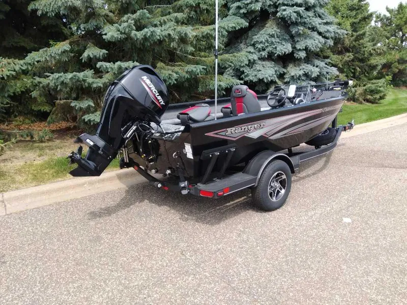 Slide: The Image of 2025 Ranger VS1665SC boat with Mercury engine on trailer, parked near trees. - 5