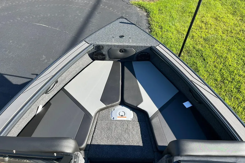 Slide: The Image of 2026 Lund 1875 Crossover XS boat interior with gray seating and carpeted flooring. - 10