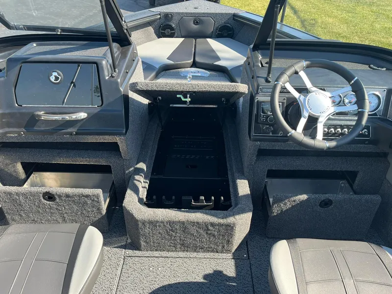 Slide: The Image of 2026 Lund 1875 Crossover XS boat interior with steering wheel and storage compartments. - 13