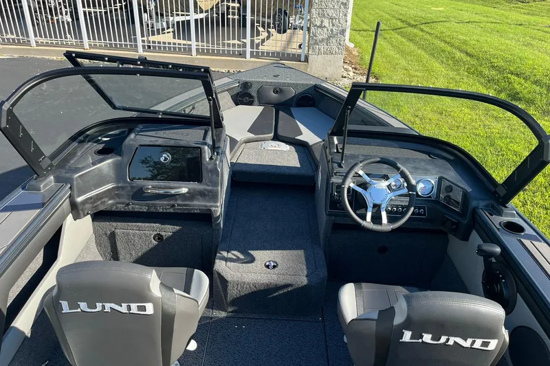 Slide: The Image of 2026 Lund 1875 Crossover XS boat interior with steering wheel and seating. - 14