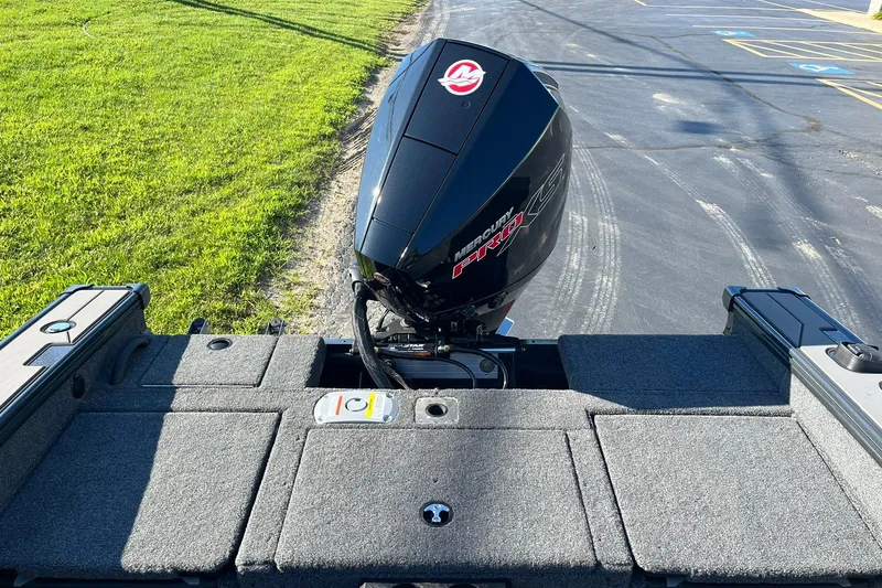 Slide: The Image of 2026 Lund 1875 Crossover XS boat with Mercury Pro XS engine, parked on pavement. - 17