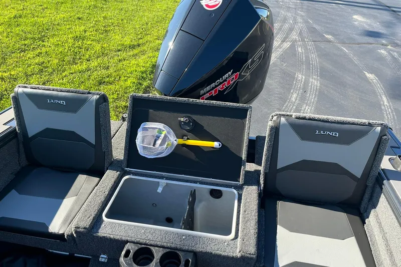 Slide: The Image of 2026 Lund 1875 Crossover XS boat interior with storage compartment and Mercury Pro XS engine. - 18