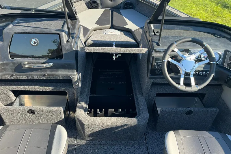 Slide: The Image of 2026 Lund 1875 Crossover XS boat interior with steering wheel and storage compartments. - 26