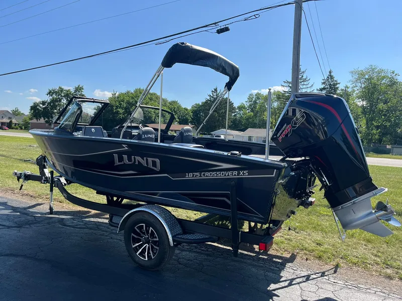 Slide: The Image of 2026 Lund 1875 Crossover XS boat on trailer, parked outdoors on a sunny day. - 41