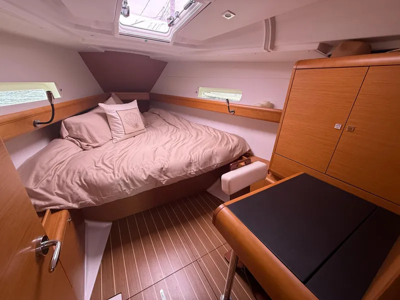 Slide: The Image of Cozy cabin interior of 2011 Jeanneau 409 sailboat with wood finish and comfortable bedding. - 15