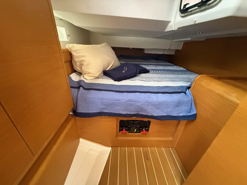 Slide: The Image of Cozy cabin interior of 2011 Jeanneau 409 sailboat with striped bedding and wooden finish. - 17