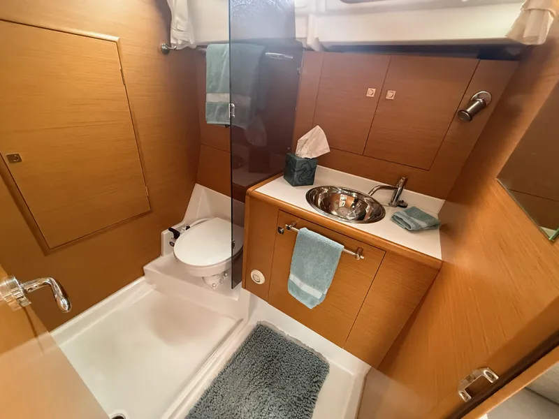 Slide: The Image of Luxurious bathroom in a 2011 Jeanneau 409 yacht, featuring modern fixtures and wooden cabinetry. - 18