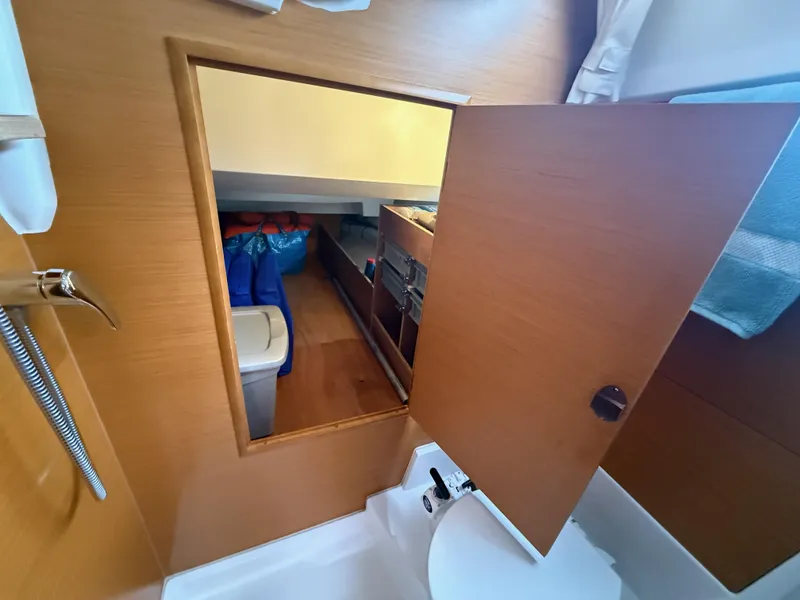 Slide: The Image of Interior view of 2011 Jeanneau 409 sailboat, featuring a wooden storage compartment. - 19