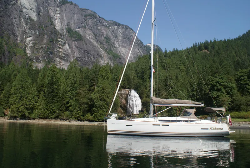 Slide: The Image of Sailboat Jeanneau 409 (2011) anchored near waterfall and forested cliffs. - 2