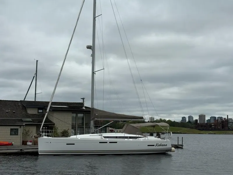 Slide: The Image of 2011 Jeanneau 409 sailboat docked by a house, overcast sky in the background. - 24