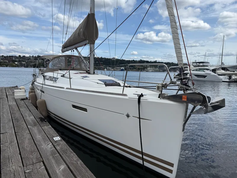 Slide: The Image of 2011 Jeanneau 409 sailboat docked at a marina under a partly cloudy sky. - 3