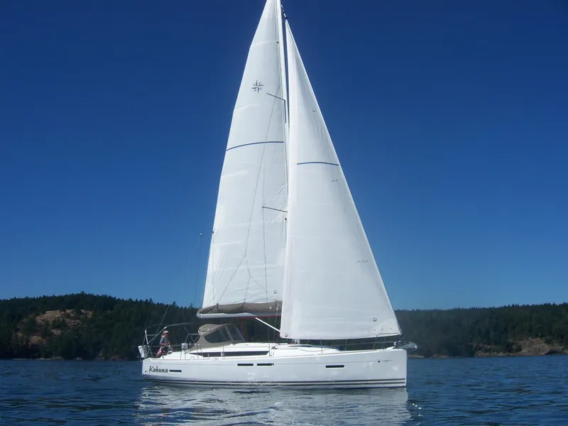Slide: The Image of 2011 Jeanneau 409 sailboat on calm water under clear blue sky. - 32