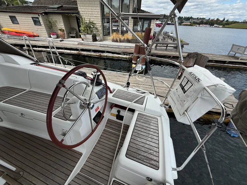 Slide: The Image of Cockpit of 2011 Jeanneau 409 sailboat docked by a wooden pier. - 7