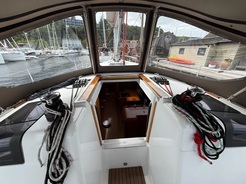 Slide: The Image of Interior view of 2011 Jeanneau 409 sailboat cockpit with ropes and marina background. - 8