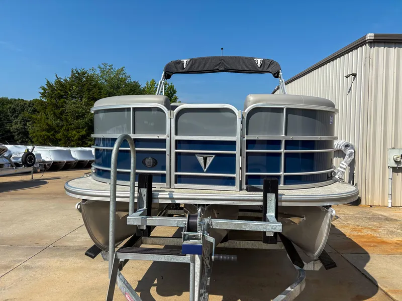 Slide: The Image of 2022 Trifecta CS 24RFC pontoon boat on trailer, parked outdoors. - 2