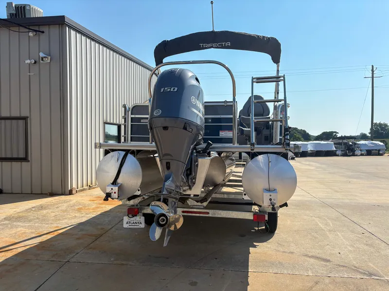 Slide: The Image of 2022 Trifecta CS 24RFC pontoon boat with Yamaha 150 engine, parked outdoors. - 3