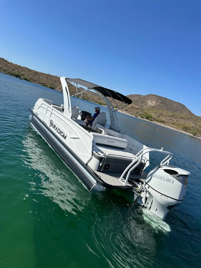 Slide: The Image of 2024 Paradigm 27SS boat cruising on a lake with clear blue skies. - 5