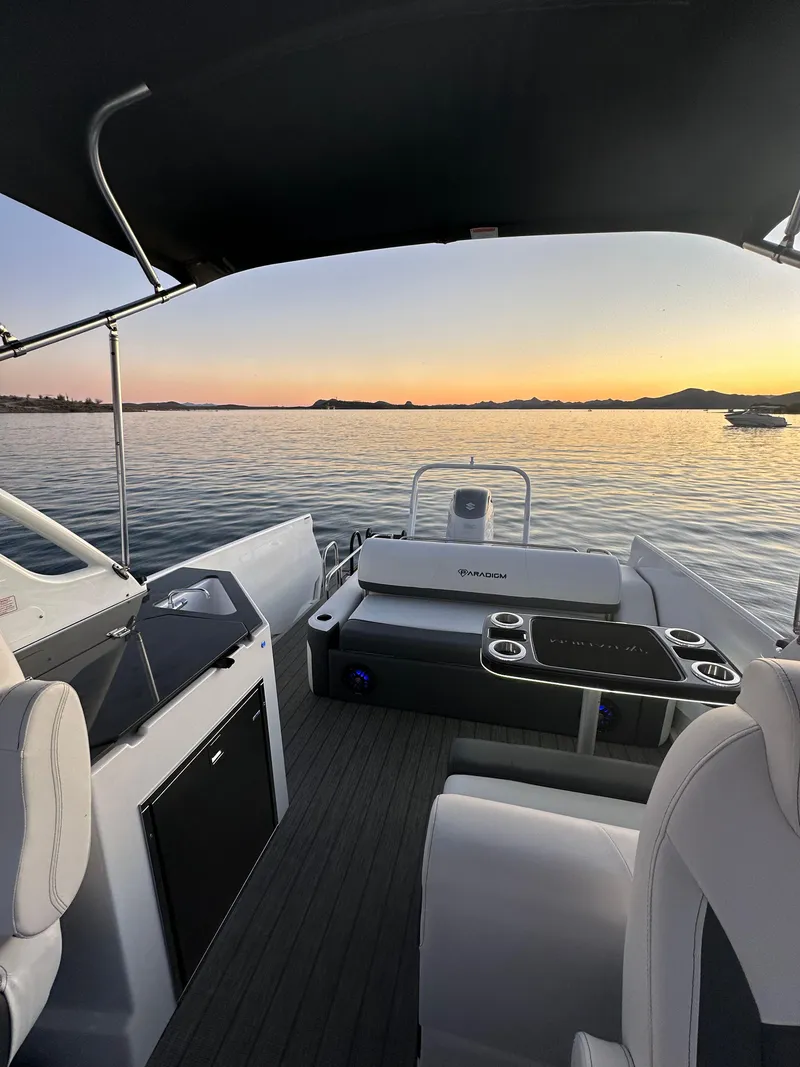 Slide: The Image of 2024 Paradigm 27SS boat interior at sunset, featuring sleek seating and modern amenities. - 6