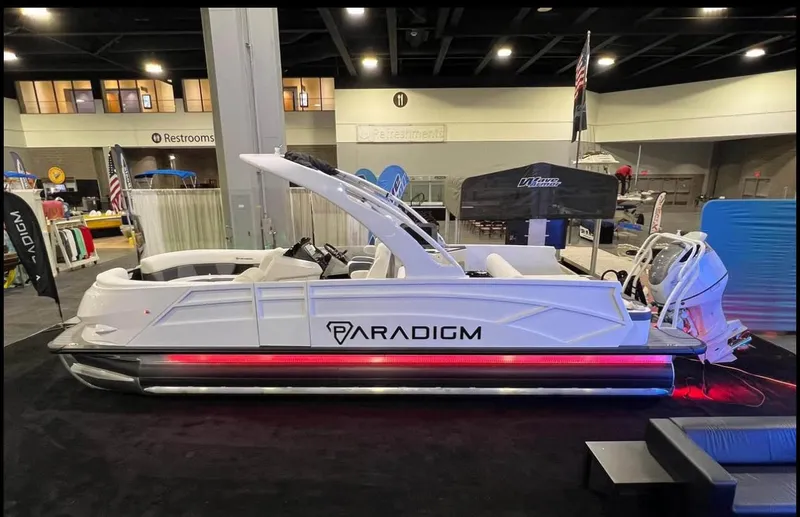 Slide: The Image of 2024 Paradigm 27SS pontoon boat displayed indoors with modern design and lighting. - 7