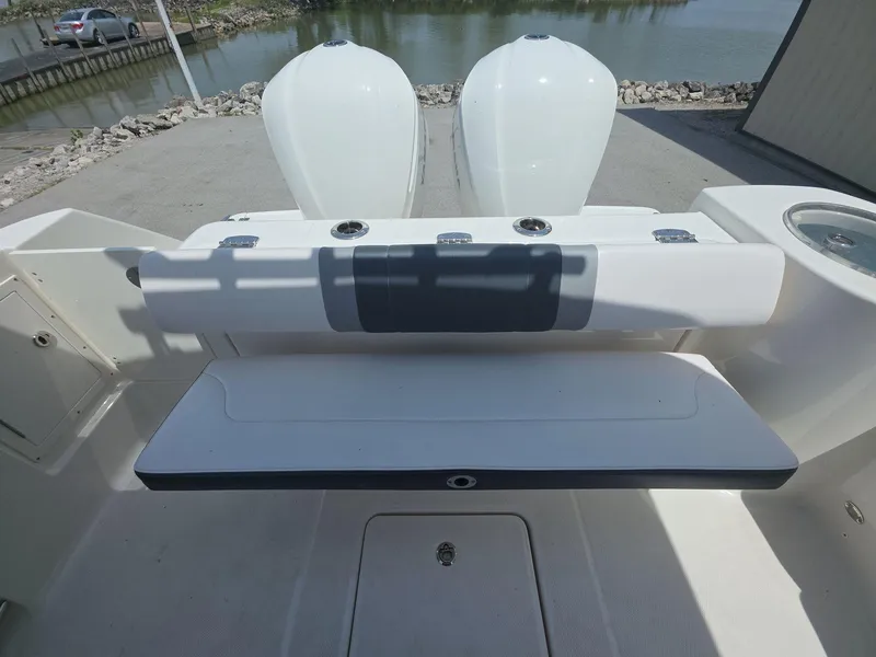 Slide: The Image of 2021 Robalo R272 Center Console boat with dual engines, docked near a calm waterway. - 14