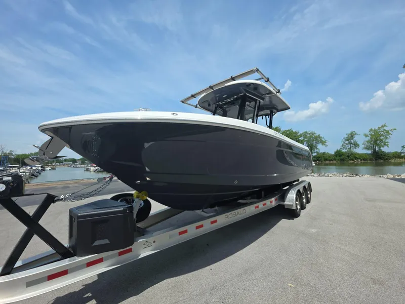 Slide: The Image of 2021 Robalo R272 Center Console boat on trailer by waterfront. - 2