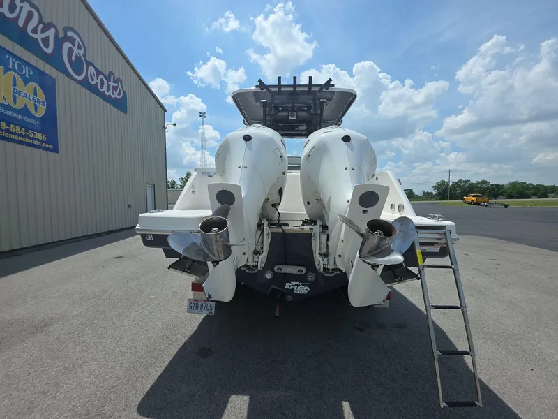 Slide: The Image of 2021 Robalo R272 Center Console boat with dual outboard engines, parked near a dealership. - 4
