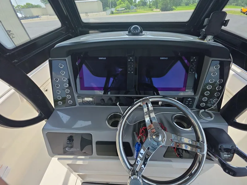 Slide: The Image of 2021 Robalo R272 Center Console dashboard with dual Simrad displays and steering wheel. - 9