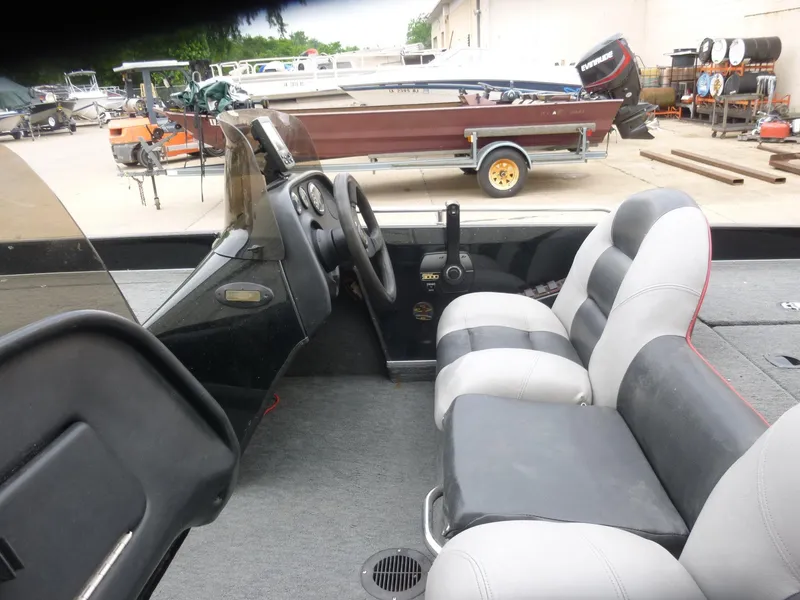 Slide: The Image of 1999 Viper Boats Cobra 180 interior with dual seats and steering wheel, parked in a boatyard. - 10