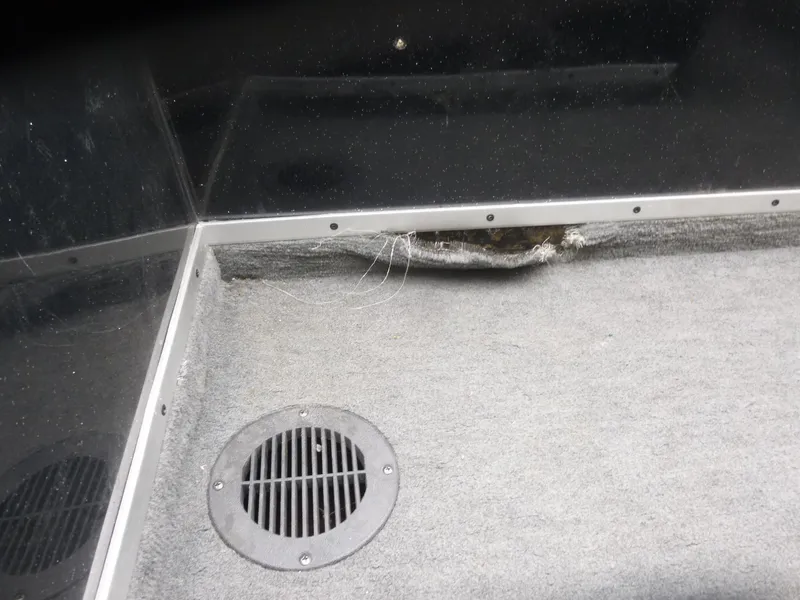 Slide: The Image of 1999 Viper Boats Cobra 180 interior with damaged carpet and floor vent. - 12