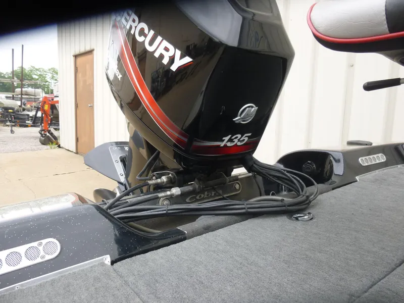 Slide: The Image of 1999 Viper Boats Cobra 180 with Mercury 135 outboard motor, parked near a building. - 5