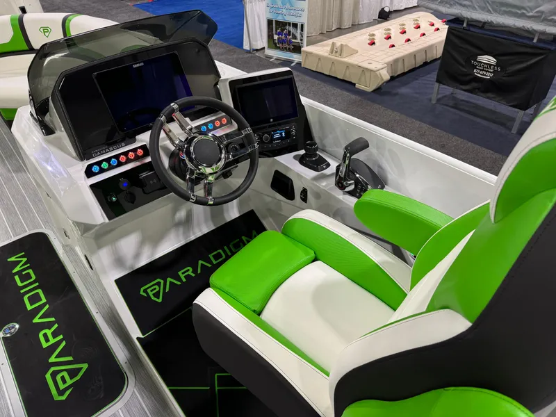 Slide: The Image of 2025 Paradigm 25SS boat interior with green and white seating, modern dashboard, and steering wheel. - 5